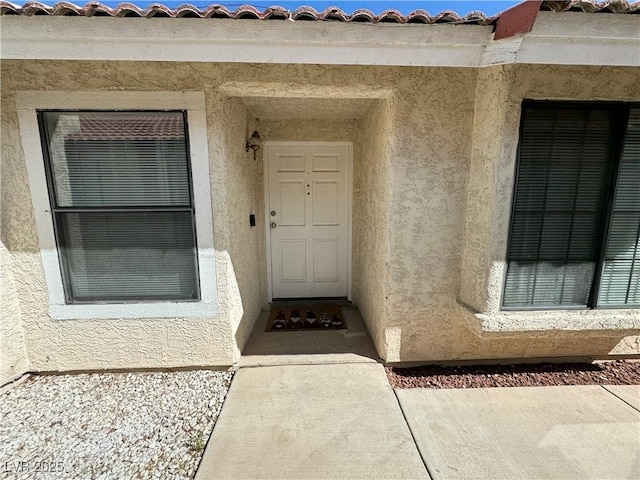 view of exterior entry featuring stucco siding