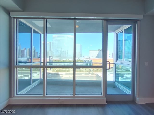 entryway featuring baseboards, a view of city, and wood finished floors