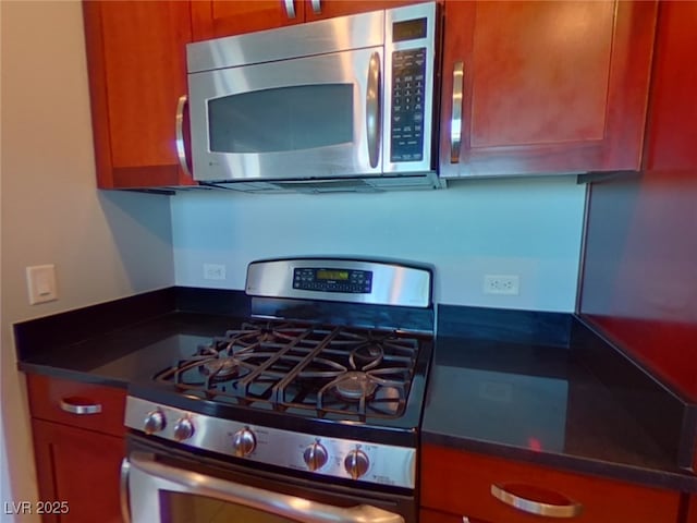 kitchen with dark countertops, brown cabinets, and stainless steel appliances