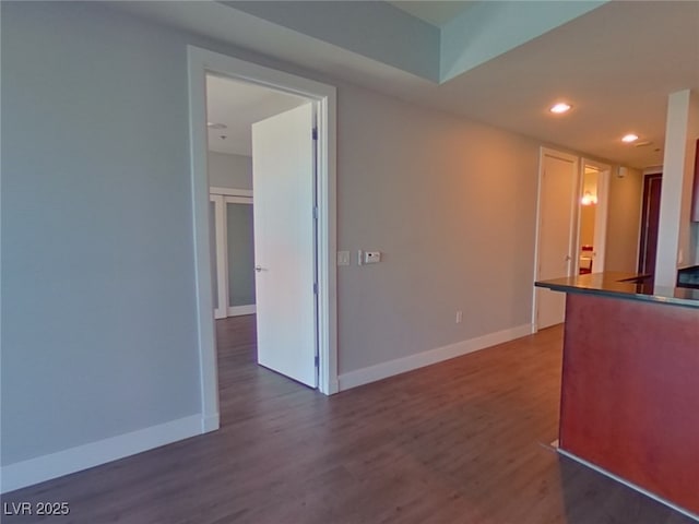 kitchen featuring dark countertops, recessed lighting, baseboards, and dark wood-style flooring