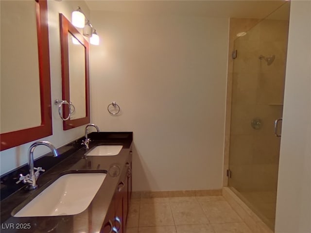 bathroom with a sink, baseboards, a stall shower, and tile patterned flooring