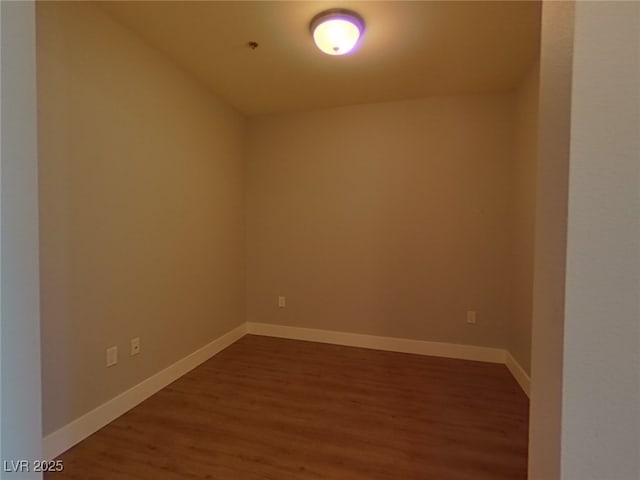 spare room with dark wood finished floors and baseboards