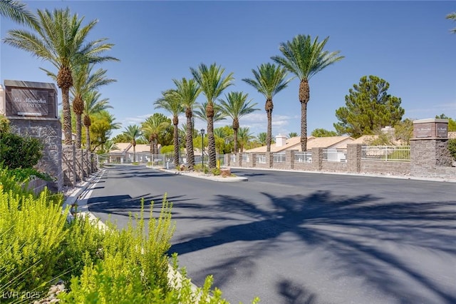 view of street featuring a gated entry, a residential view, curbs, and a gate