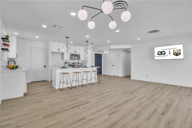 kitchen featuring visible vents, white cabinets, and stainless steel appliances