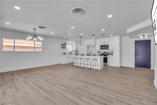 kitchen featuring white cabinetry, light wood-style flooring, visible vents, and appliances with stainless steel finishes