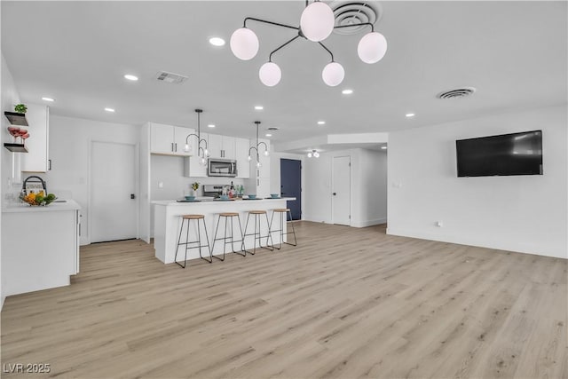 kitchen with white cabinetry, visible vents, and stainless steel appliances