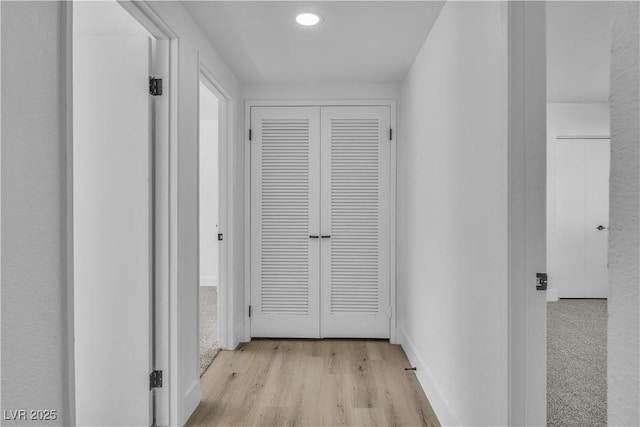 hallway featuring wood finished floors and baseboards