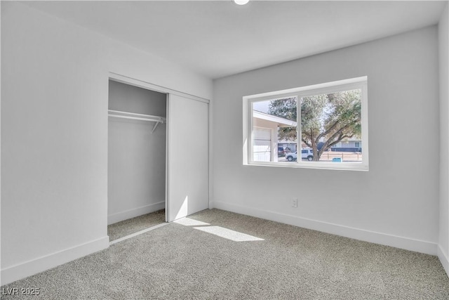 unfurnished bedroom featuring a closet, carpet flooring, and baseboards