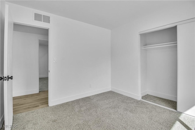 unfurnished bedroom featuring a closet, visible vents, baseboards, and carpet