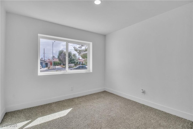 carpeted empty room featuring baseboards