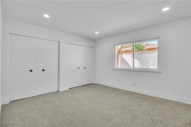 unfurnished bedroom with recessed lighting, multiple closets, and carpet floors