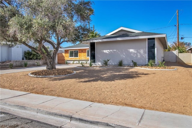 single story home featuring stucco siding and fence