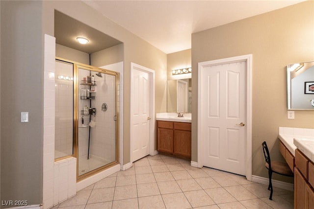 full bath featuring tile patterned flooring, a shower stall, and two vanities