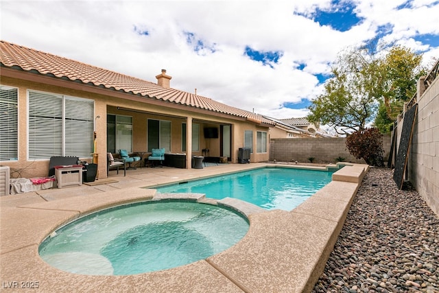 view of pool featuring a fenced backyard, a pool with connected hot tub, and a patio