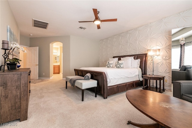 bedroom featuring arched walkways, visible vents, light carpet, and wallpapered walls