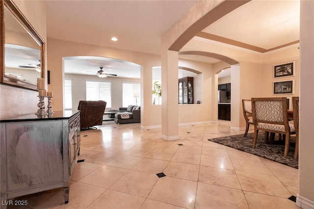 foyer featuring a ceiling fan, baseboards, light tile patterned flooring, recessed lighting, and arched walkways