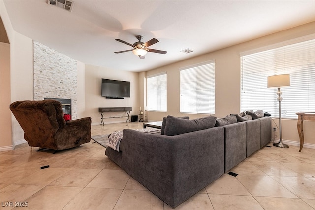 living area featuring light tile patterned floors, visible vents, and a ceiling fan