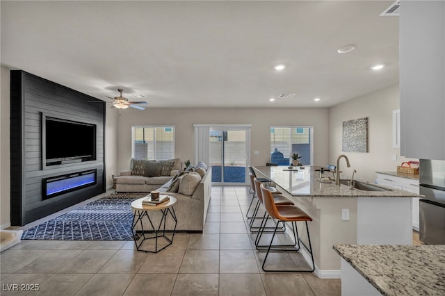 living area featuring recessed lighting, light tile patterned floors, a ceiling fan, and visible vents