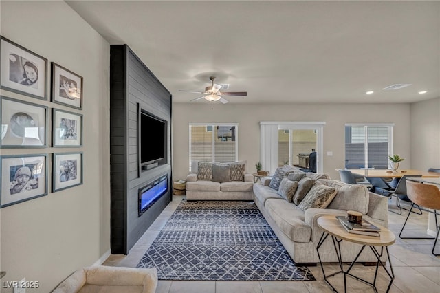 living area with light tile patterned floors, a ceiling fan, visible vents, recessed lighting, and a fireplace