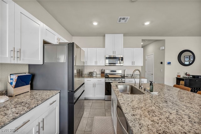 kitchen featuring a sink, white cabinets, visible vents, and stainless steel appliances