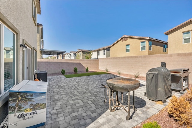 view of patio / terrace with area for grilling, a fenced backyard, and a residential view