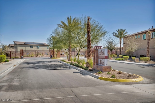 view of road with sidewalks, curbs, a gated entry, and a gate