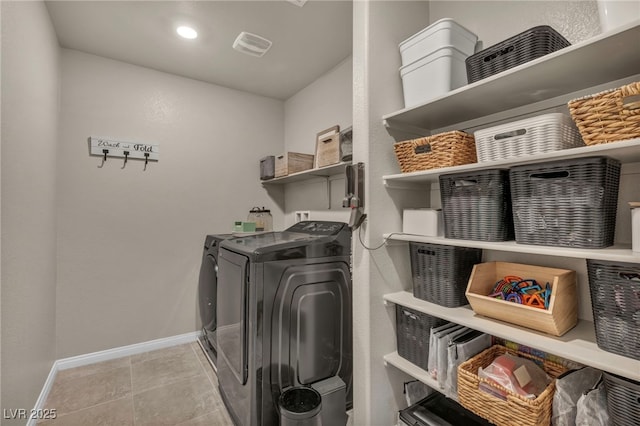 washroom with laundry area, separate washer and dryer, baseboards, and tile patterned floors