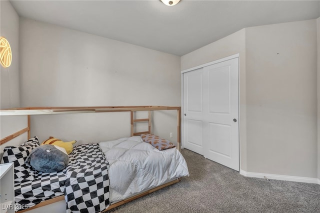 carpeted bedroom with a closet and baseboards