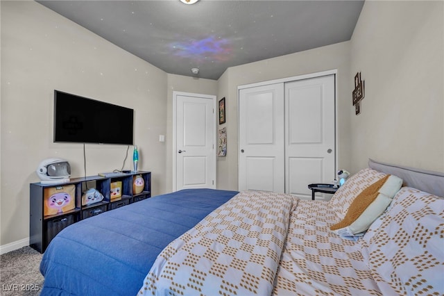 carpeted bedroom with a closet and baseboards