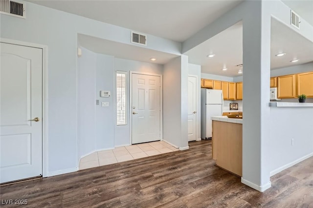 entryway featuring dark wood finished floors, visible vents, and baseboards