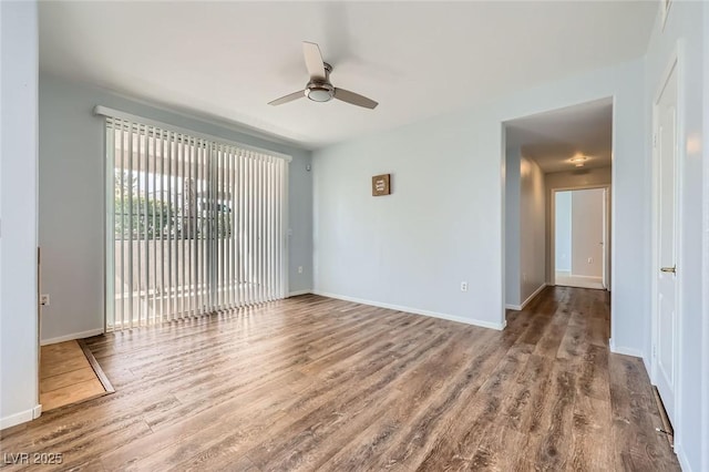 spare room with baseboards, wood finished floors, and a ceiling fan