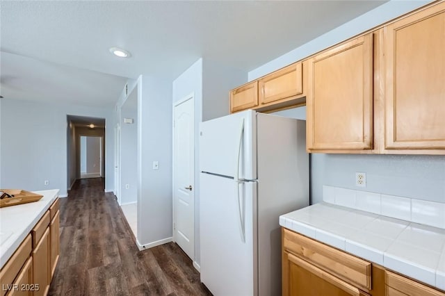 kitchen with light brown cabinets, dark wood-style floors, freestanding refrigerator, tile countertops, and recessed lighting