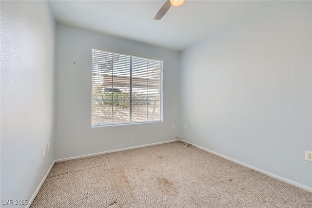 spare room featuring baseboards, a ceiling fan, and carpet floors