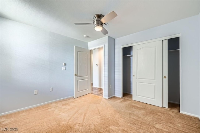 unfurnished bedroom with light carpet, baseboards, a closet, and a ceiling fan