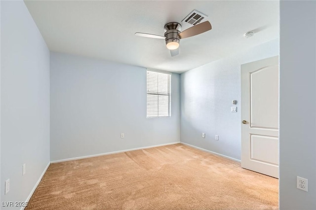 spare room with visible vents, light colored carpet, baseboards, and ceiling fan