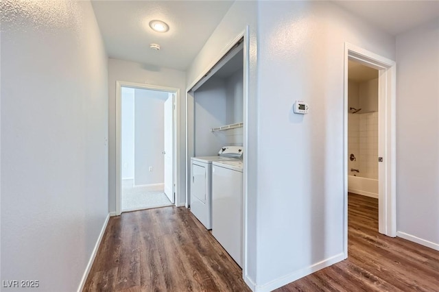 hallway featuring independent washer and dryer, baseboards, and dark wood-style flooring