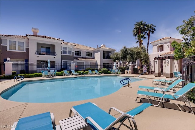 view of swimming pool with a patio and fence