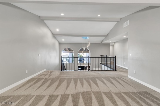 unfurnished room featuring visible vents, baseboards, carpet floors, an inviting chandelier, and vaulted ceiling with beams