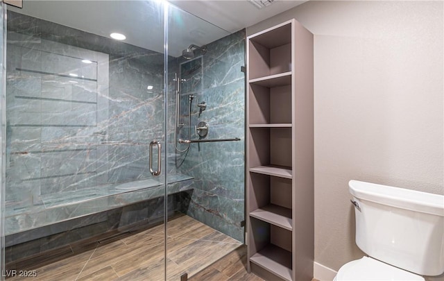 full bathroom featuring a stall shower, toilet, and wood tiled floor