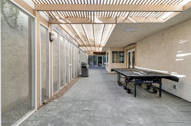 view of patio with area for grilling and a pergola