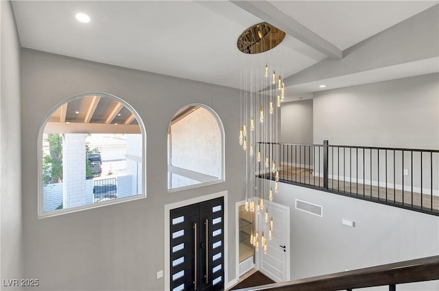 entryway featuring visible vents, an inviting chandelier, beam ceiling, a high ceiling, and recessed lighting