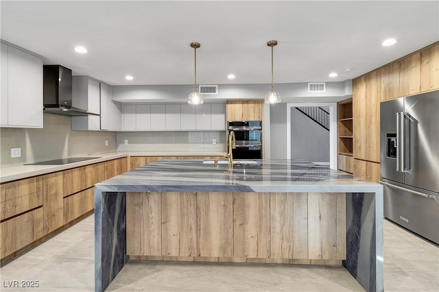 kitchen with visible vents, decorative backsplash, appliances with stainless steel finishes, wall chimney exhaust hood, and modern cabinets