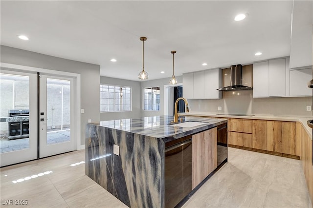 kitchen featuring a kitchen island with sink, a sink, black appliances, wall chimney range hood, and modern cabinets