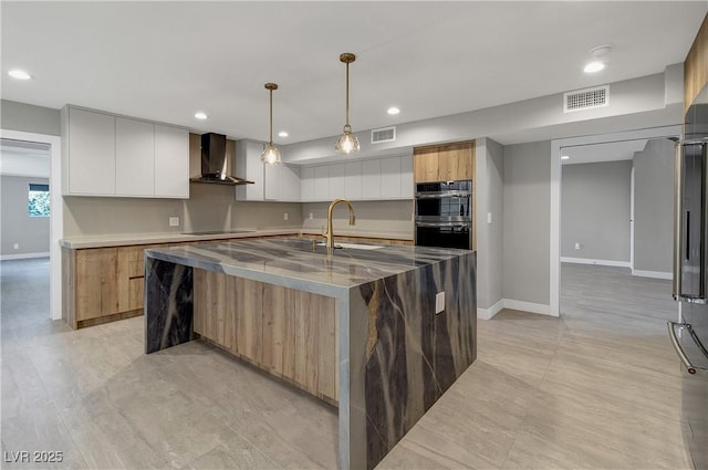 kitchen with visible vents, stainless steel double oven, wall chimney exhaust hood, black electric cooktop, and modern cabinets