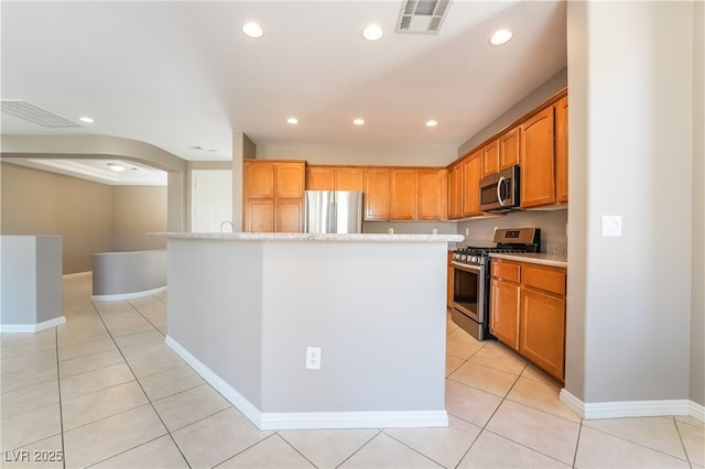 kitchen with light tile patterned floors, visible vents, and stainless steel appliances