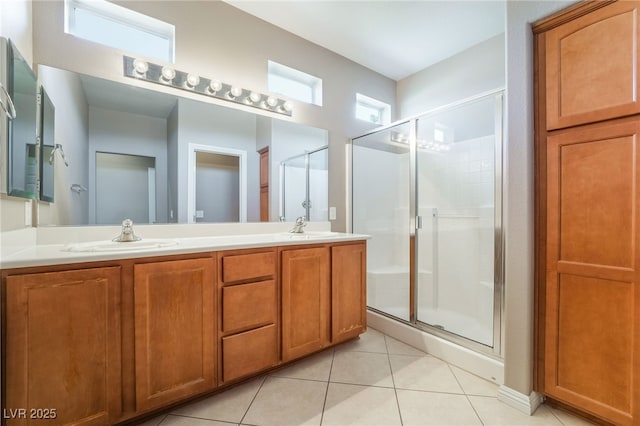 full bath with a sink, a shower stall, tile patterned floors, and double vanity