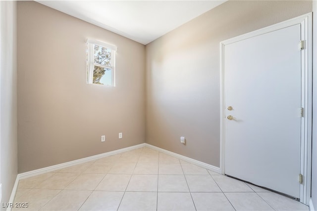 empty room featuring light tile patterned floors and baseboards