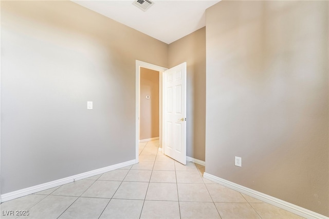 unfurnished room featuring light tile patterned floors, visible vents, and baseboards