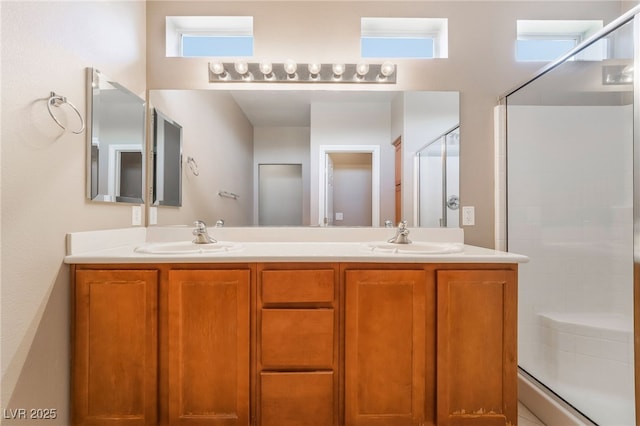 bathroom featuring a sink, a stall shower, and double vanity