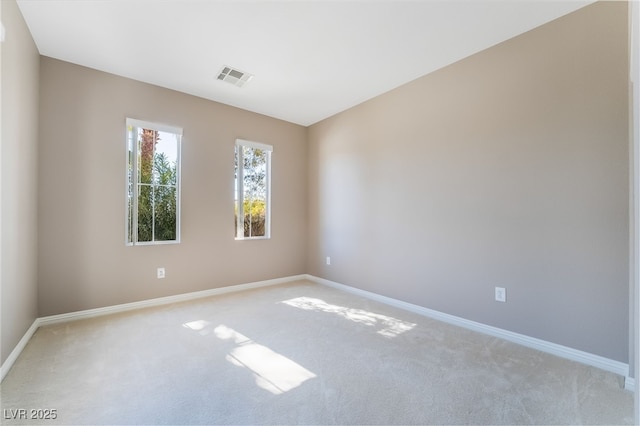 unfurnished room featuring visible vents, carpet, and baseboards